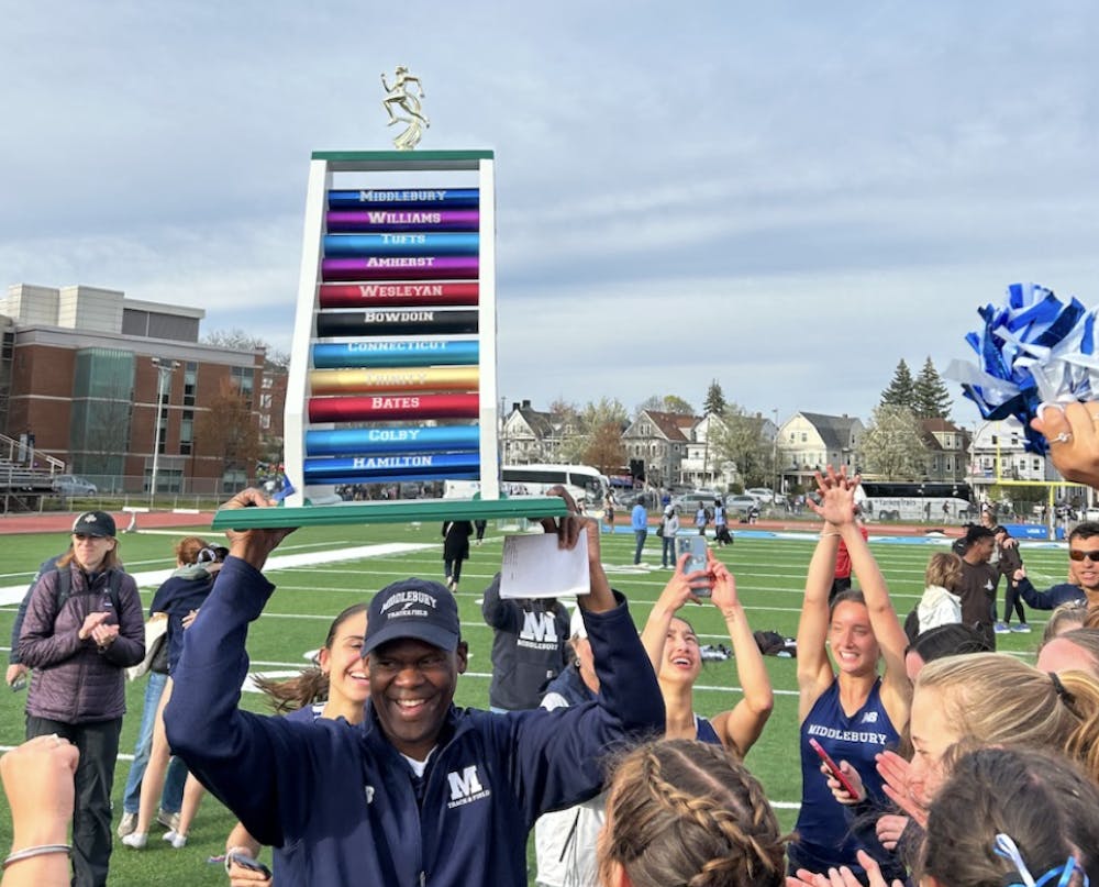 Coach Martin Beatty ’84 hoists the women’s track and field championship trophy.
