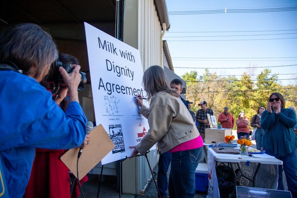 A farm representative signing the Milk with Dignity Agreement.