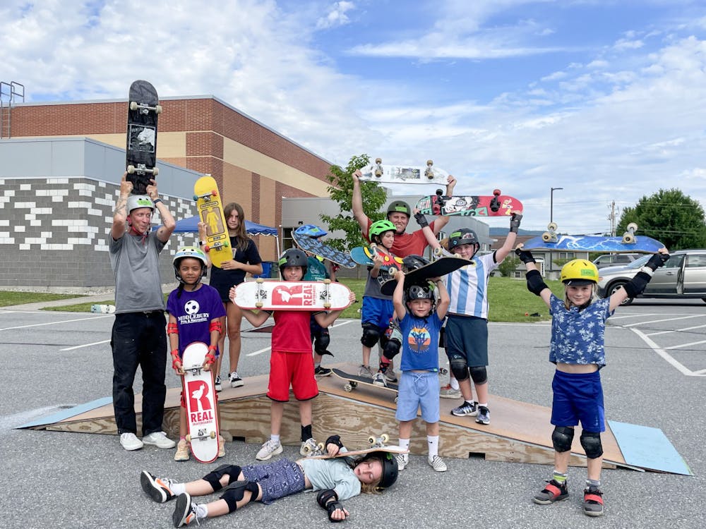 Community kids and members of the Skatepark Project pose dowtown on a mini-ramp.