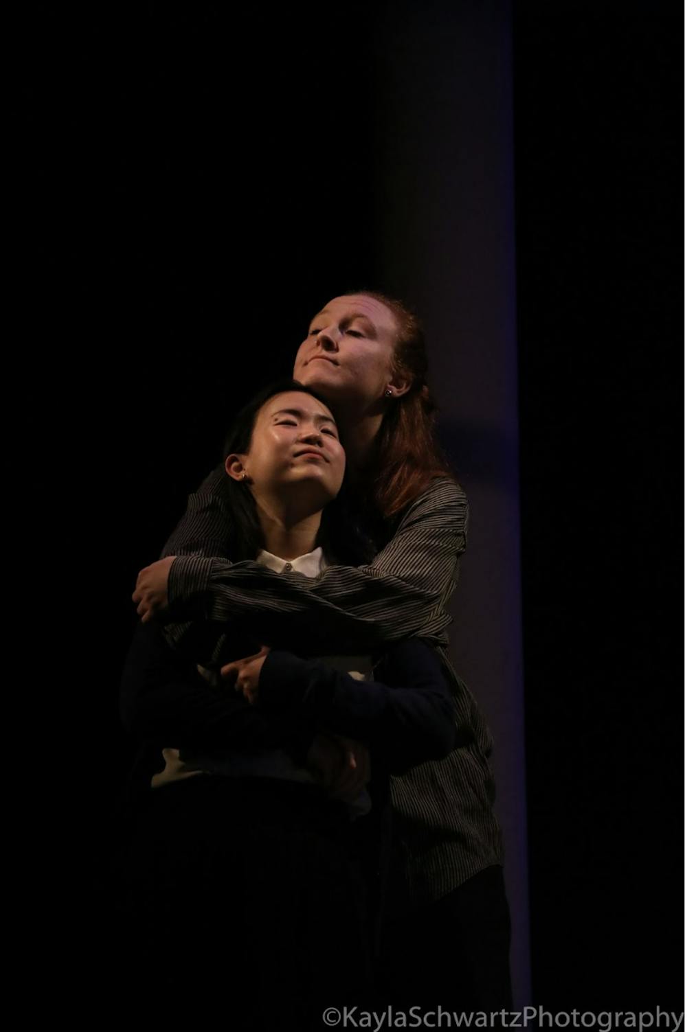 Actors embrace during performance