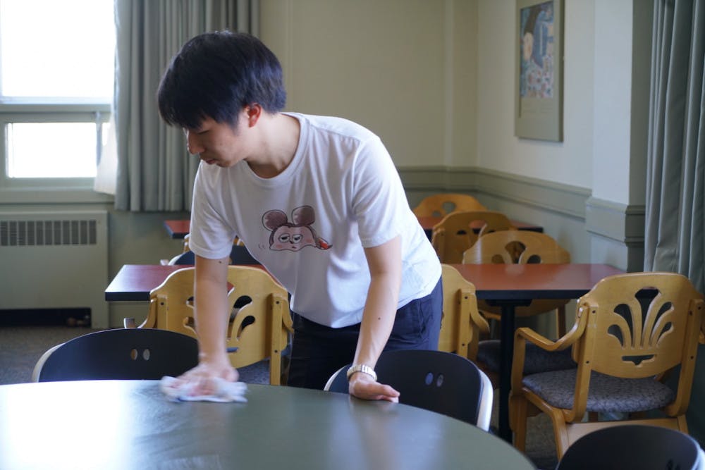 <span class="photocreditinline">YVETTE SHI/THE MIDDLEBURY CAMPUS</span><br />Language Table manager Stephen Chen ’19.5 cleans up after a busy lunch period.