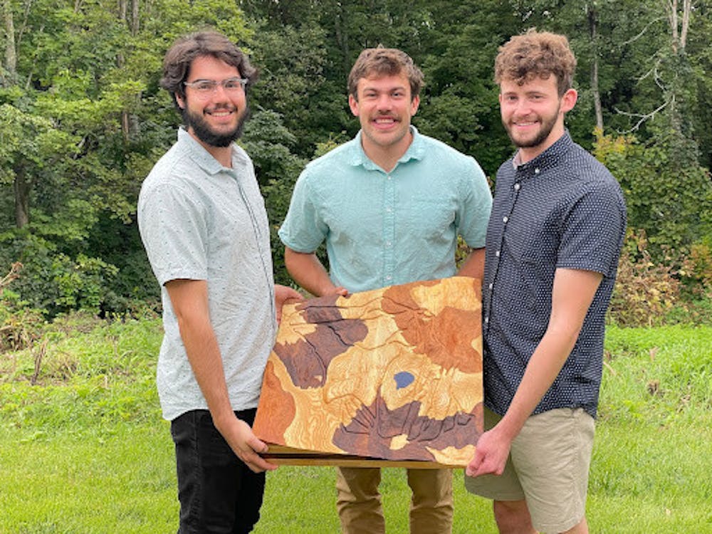 Founders of Treeline Terrains — Alex Gemme ’21, Nathaniel Klein ’21, and Jacob Freedman ’21 — hold a large Snow Bowl carving outside of the Innovation Hub, where the business started. Their company creates 3-D landscape models that you can touch. (Courtesy of Alex Gemme)
