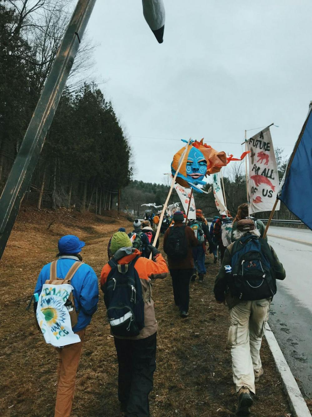 <span class="photocreditinline">Divya Gudur</span><br />Protesters wave flags as they march towards the Statehouse in Montpelier to raise climate awareness.