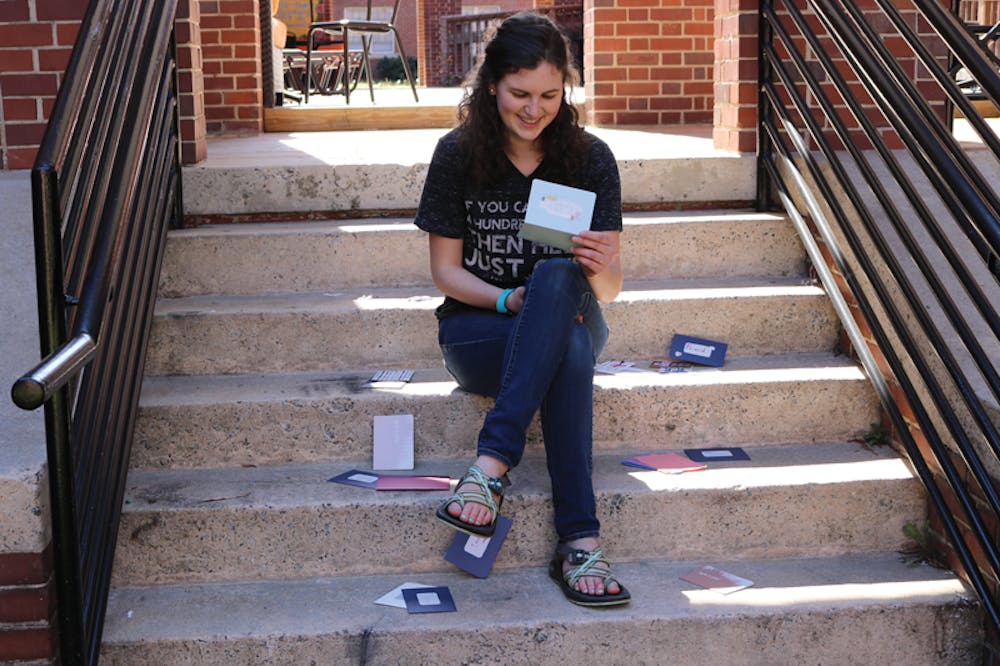 President of Campus Cursive Rebecca Braun sits and reads one of her favorite letters in the courtyard of the Mary Erin Porter residence hall. 