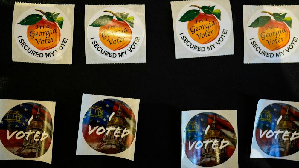 Stickers are seen at The High Museum of Art voting center on the first day for early voting in Georgia, Tuesday, Oct. 13, 2026, in Atlanta. (AP Photo/Mike Stewart)