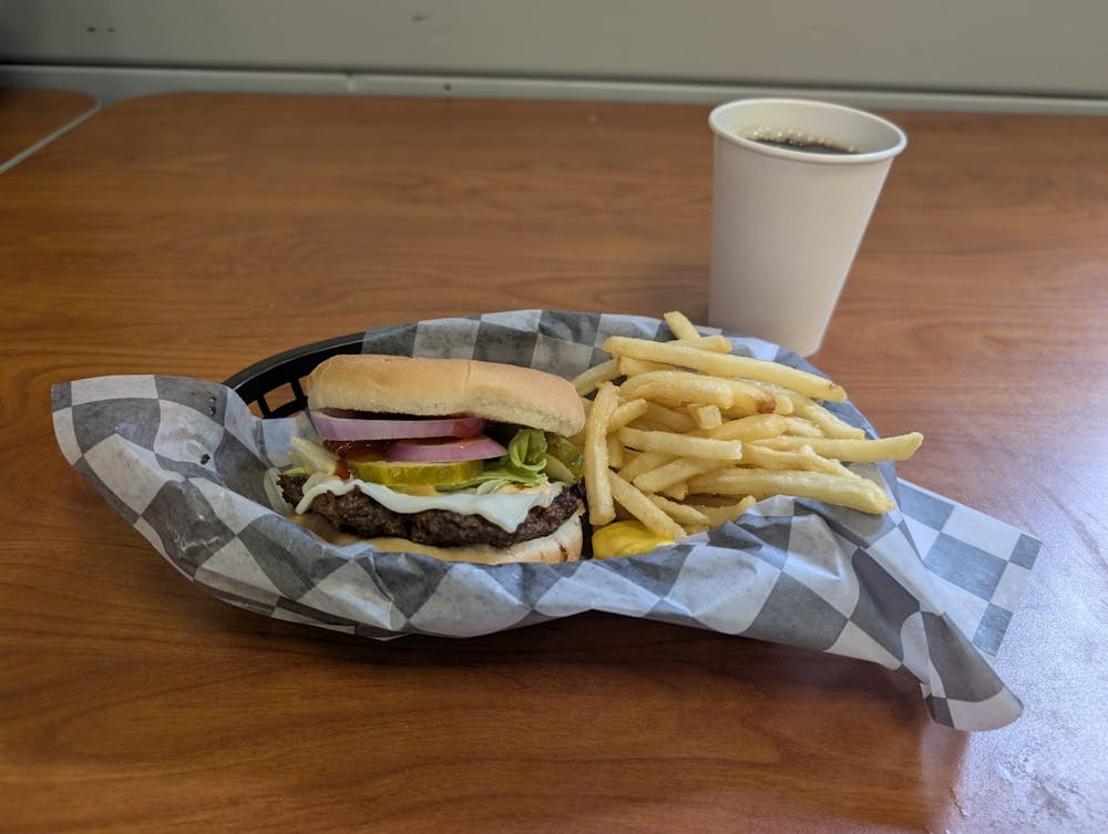 A smash burger from the Fresh Food Company replete with pickles, lettuce and onions.