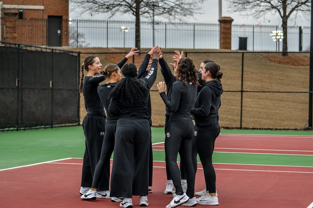 The women's tennis team meets together during a match against the College of Charleston on Jan. 24.