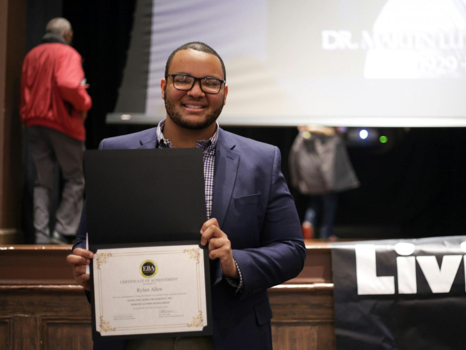 Mercer student Rylan Allen poses for a photo holding a certificate of achievement from the Alpha Phi Alpha Fraternity awarded to him for his commitment to “Living The Dream” as a student leader at Mercer.