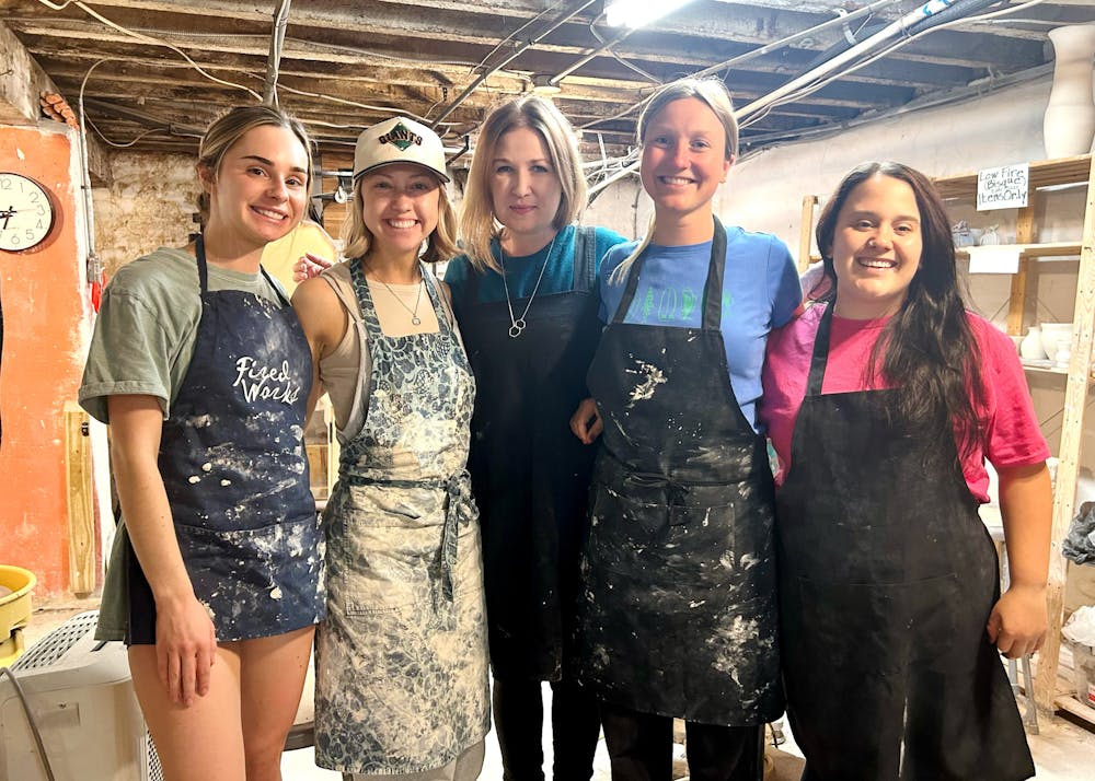 <p>Johnnie Skelton (center) poses with her pottery students at her Beginning Wheel class on Oct. 20. </p>