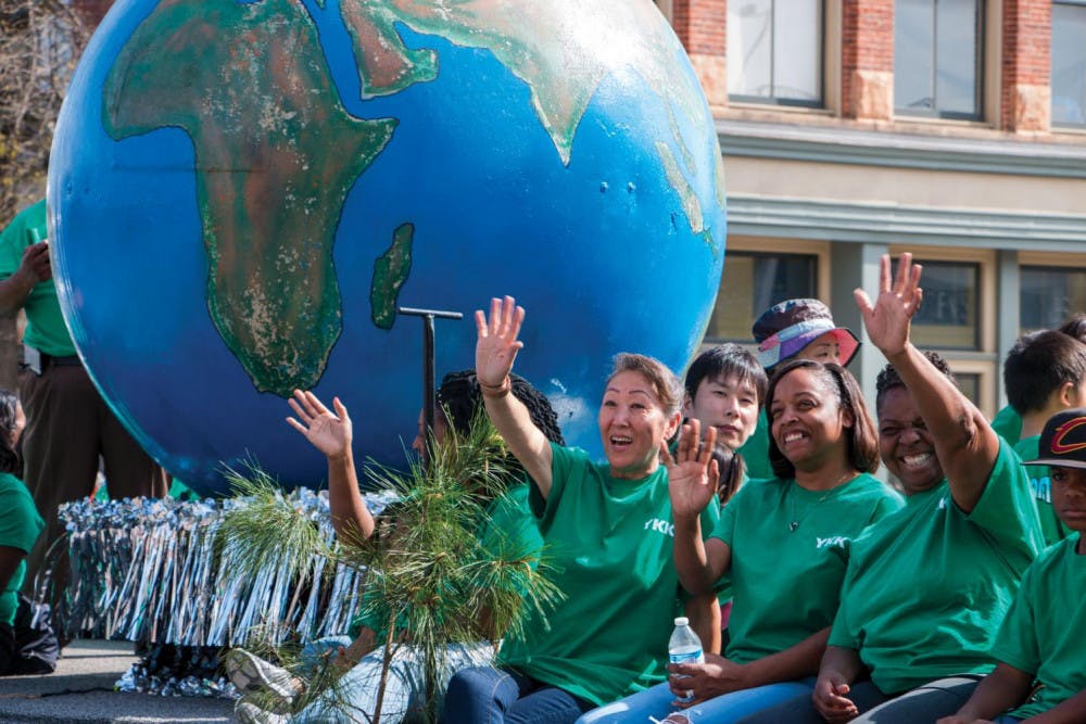 YKK employees wave from the top of a float at the Cherry Blossom Festival.