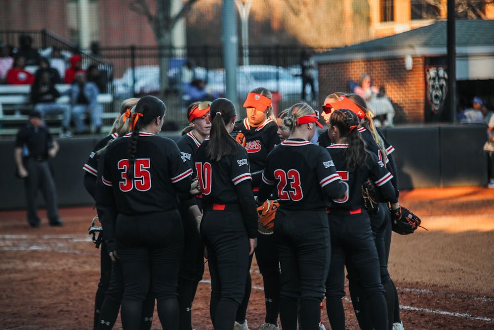 The Mercer softball team huddles up during a game.