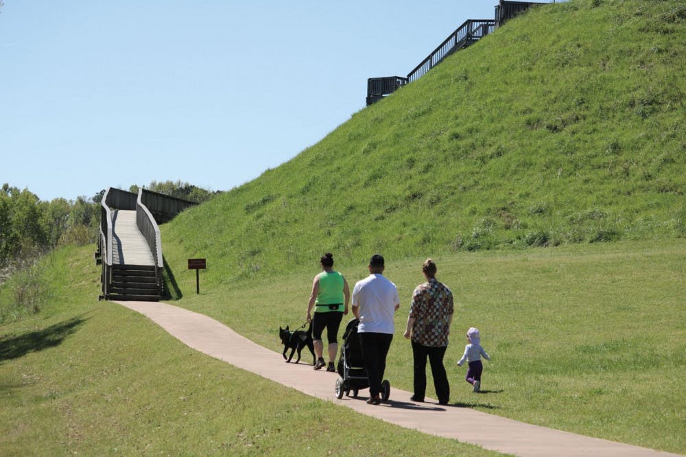 The Ocmulgee National Park is home of the Great Temple Mound and Town Site. A family hikes up the trail and stairs to see an overview of downtown Macon.