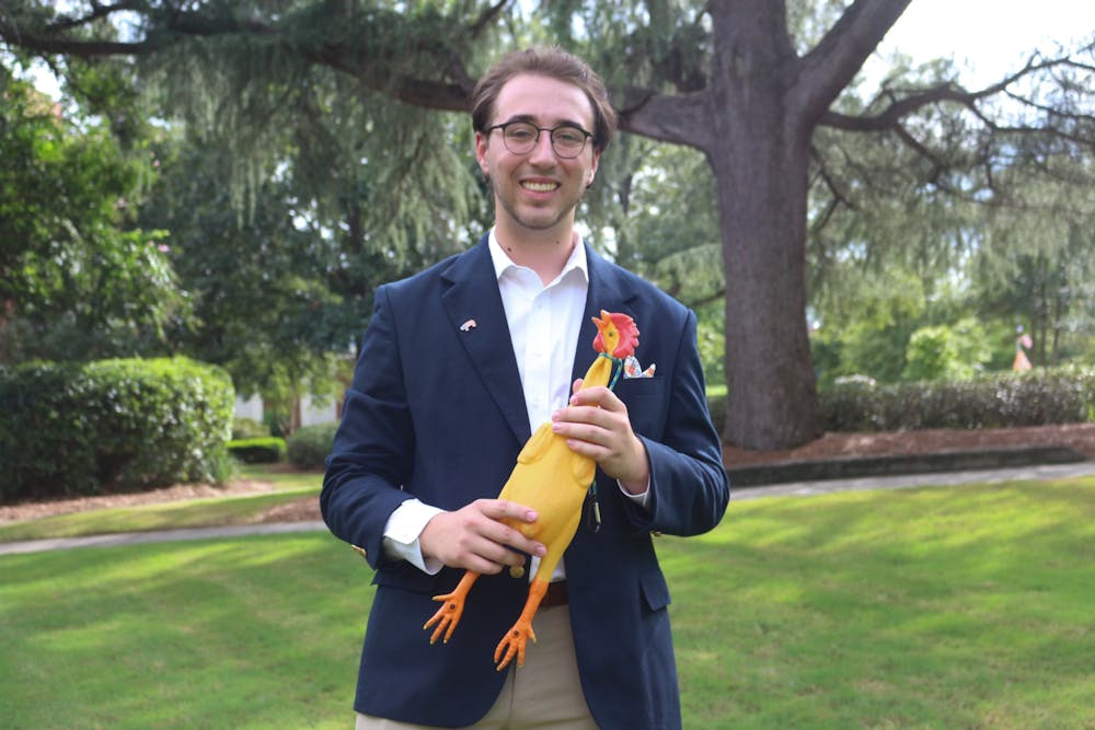 Eric Foreman poses on the Historic Quad with his rubber chicken, an award he received during his time as a Boy Scout.