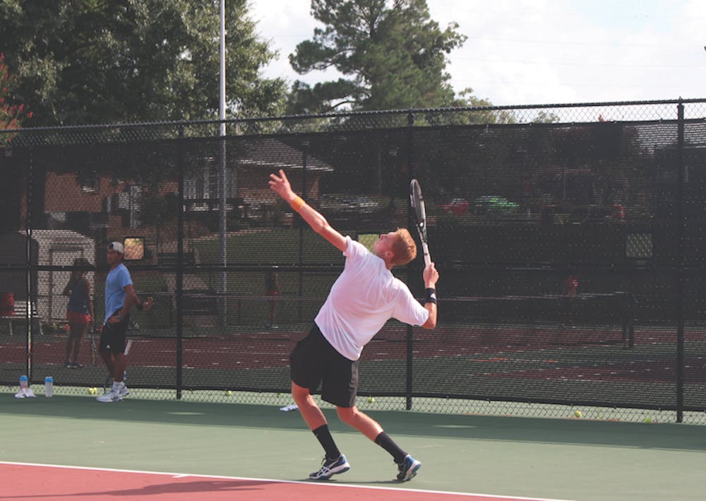 Ruben Vanoppen serves the ball at tennis practice.