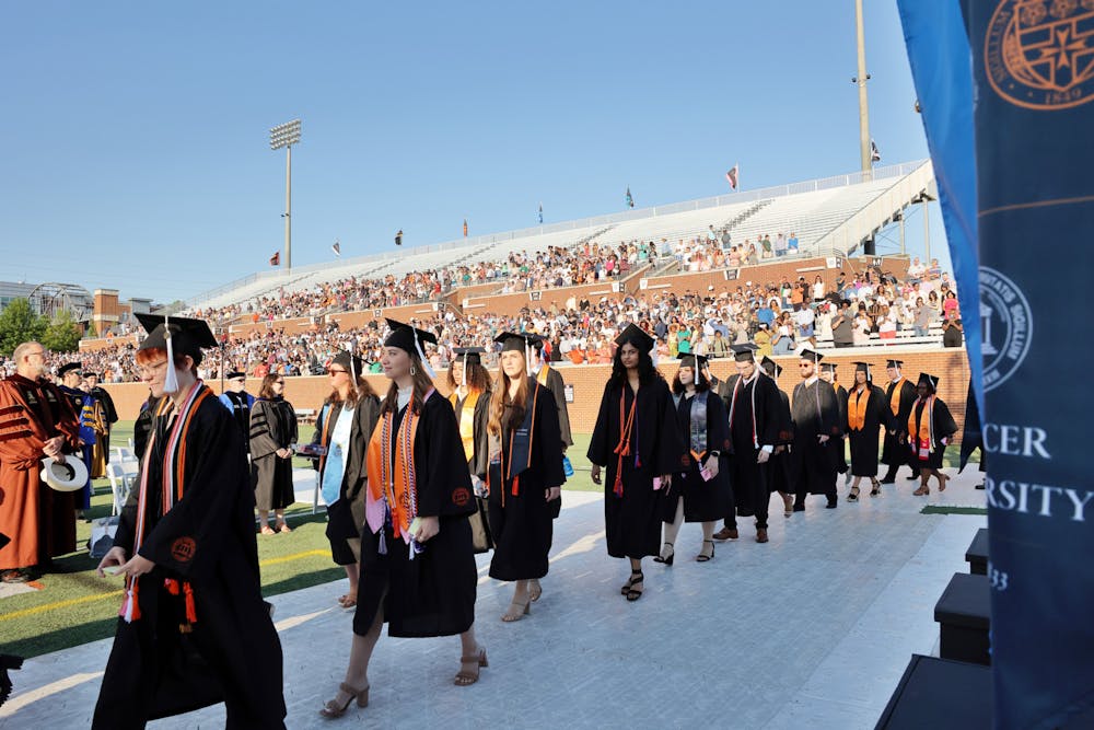 Undergraduate students walk to their seats during Mercer's Macon campus commencement in 2022. Photo by Leah Yetter.