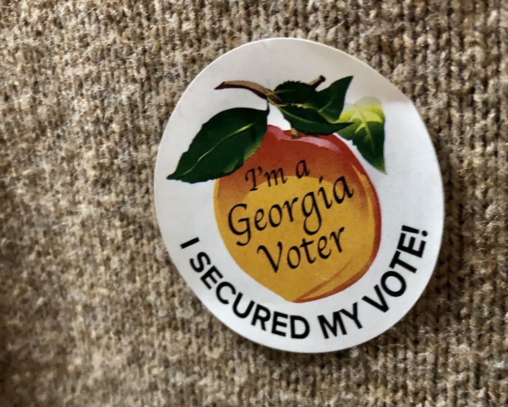 <p>An &quot;I&#x27;m a Georgia Voter&quot; sticker featuring the iconic peach imagery sits on a voter&#x27;s sweater. Georgia residents turned out to the polls in record numbers for the 2022 midterms, especially in early voting before Election Day.</p>