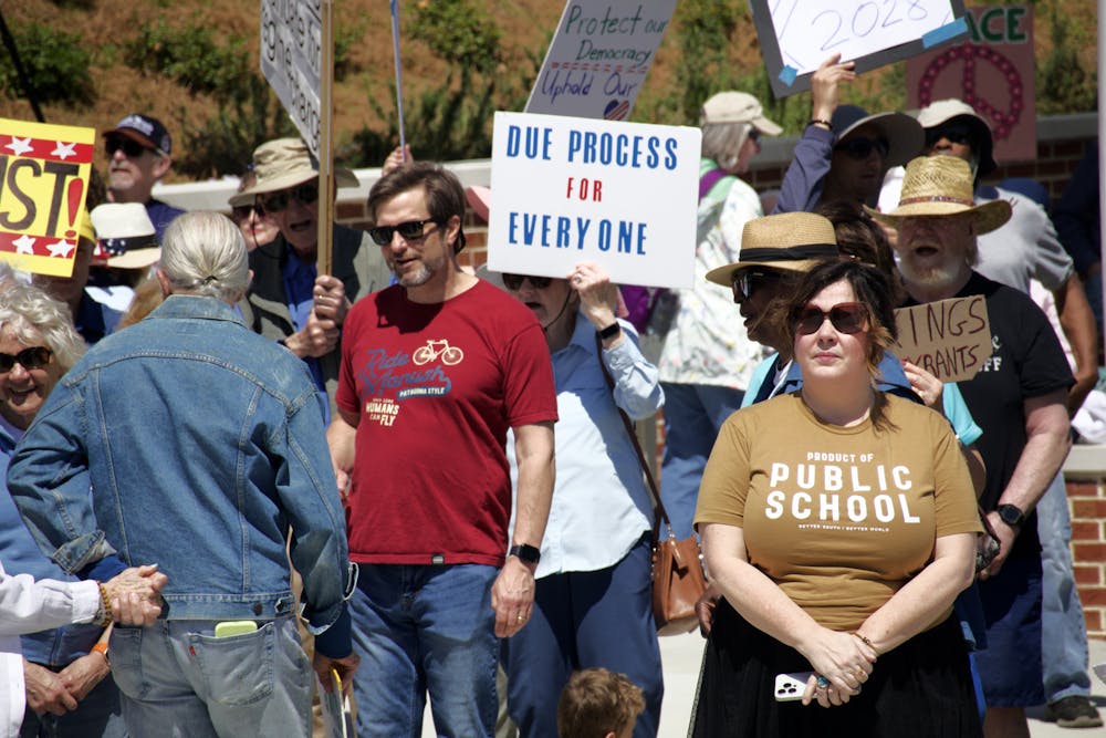 Protesters talk, wave signs and listen to speakers at the "No Kings" protest in downtown Macon on Saturday, March 28, 2026.