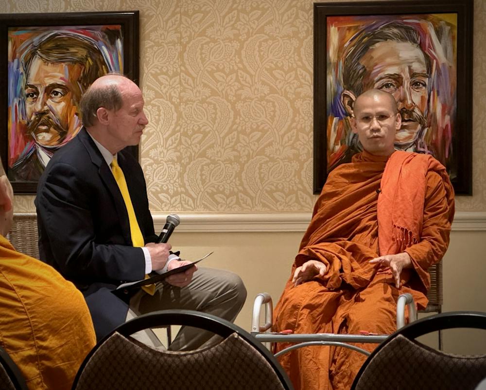 Craig McMahan speaks to the venerable Phar Ajarn Maha Dam when the Buddhist monk first spoke at Mercer in the President's Dining Room on March 18, 2026.
