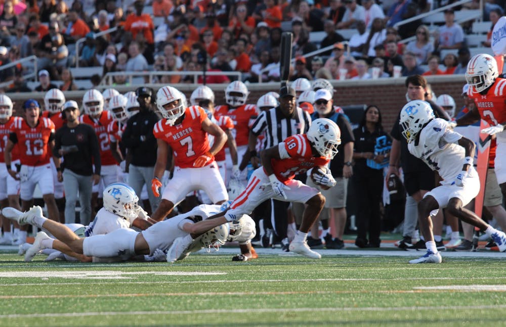 Adjatay Dabbs '26 stretches against a defender's tackle to earn extra yardage against Presbyterian College on Aug. 30.