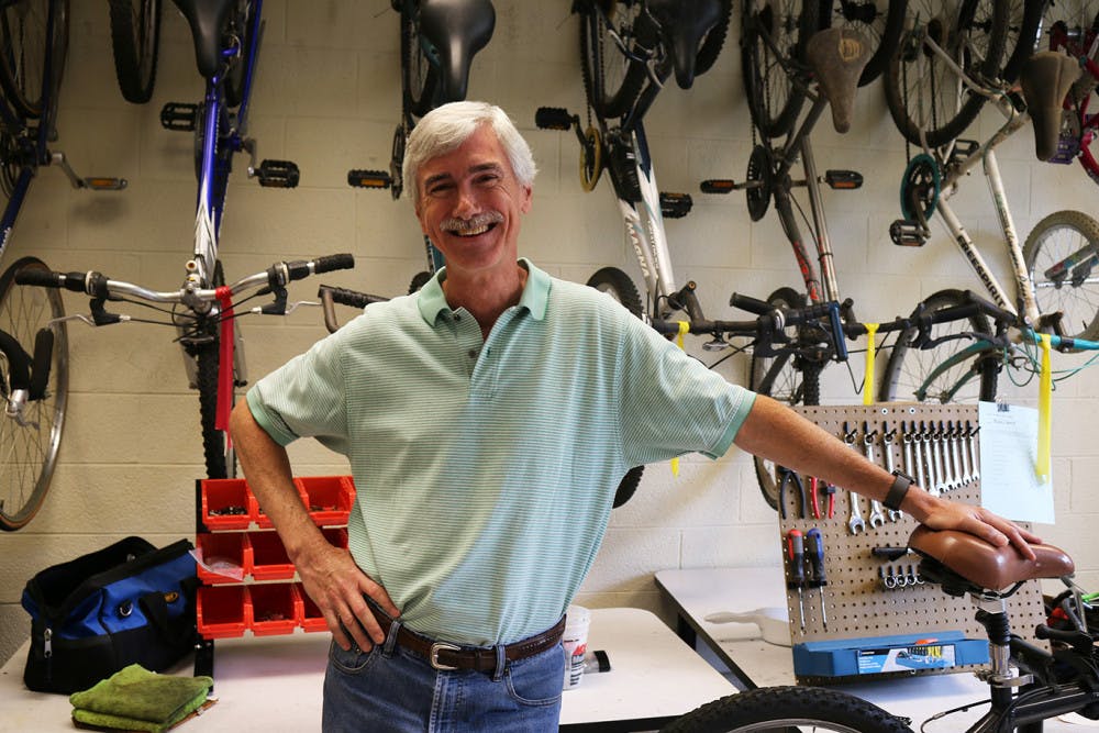 Nathan Watson poses in front of a wall of bikes at the Learn and Earn Bike Shop in Macon.