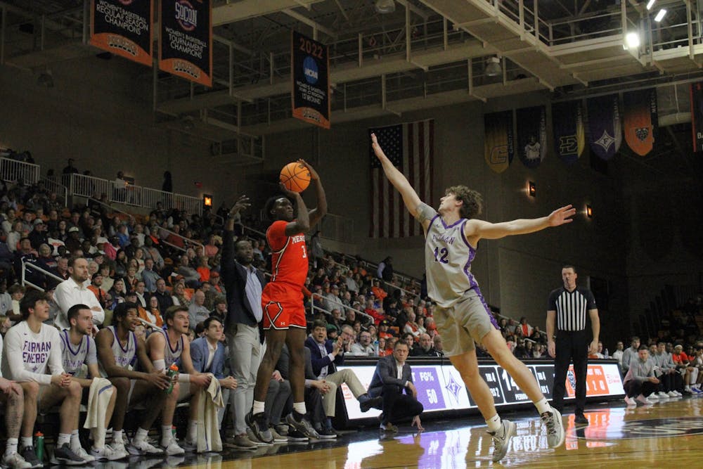 Tyler Johnson '25 launches a shot in front of the Furman University bench. The former Peach Belt Player of the Year shot 4-for-8 from deep against the Paladins, but ultimately his 16 points were not enough to overcome the SoCon foe.