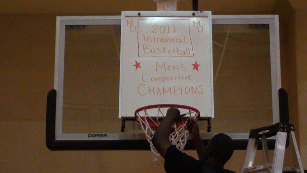 (photo courtesy of Mercer Intramurals) Primetime's Josiah Ojo cuts down the nets following his team's victory.