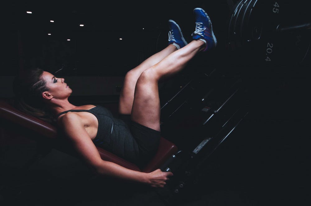 A woman does leg presses at the gym. 