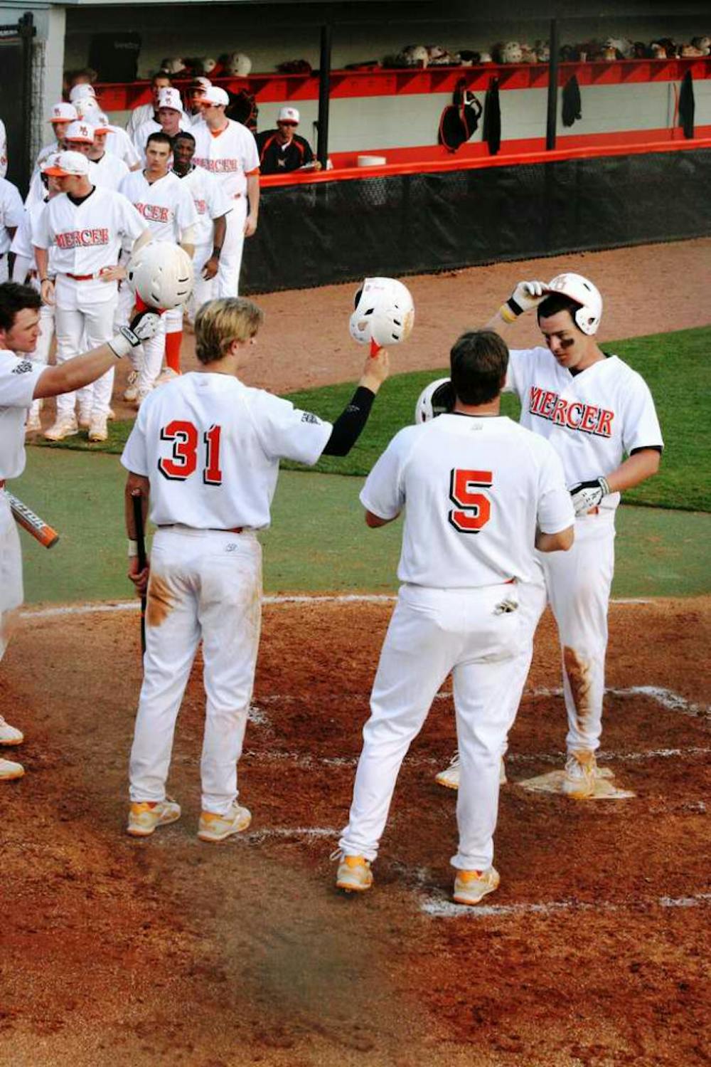 (Alex Lockwood / Cluster Staff) Joe Winker (far right) receives a tip of the cap from his teammates after a three homerun game against Liberty this past weekend.