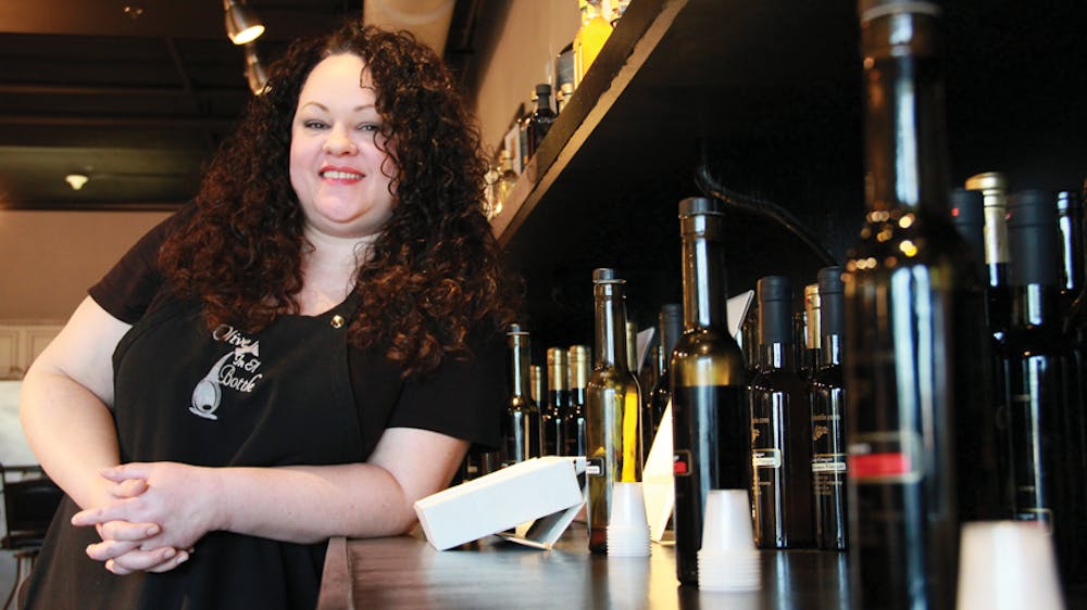 Brandi Judd, sales associate at Olive in a Bottle, poses alongside some of her favorite products at the store.
