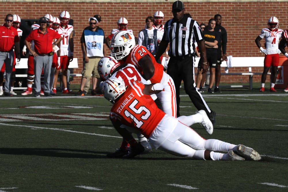 Ken Standley '25 and Marques Thomas '25 tackles VMI's VJ Johnson in a game on Saturday, Sept. 30.
