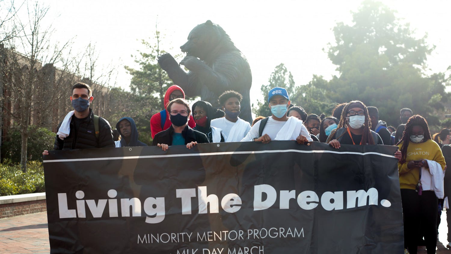 Students prepare to march in honor of Martin Luther King Jr. outside of Mercer’s University Center, holding a banner that says “Living The Dream,&quot; in January 2022. 