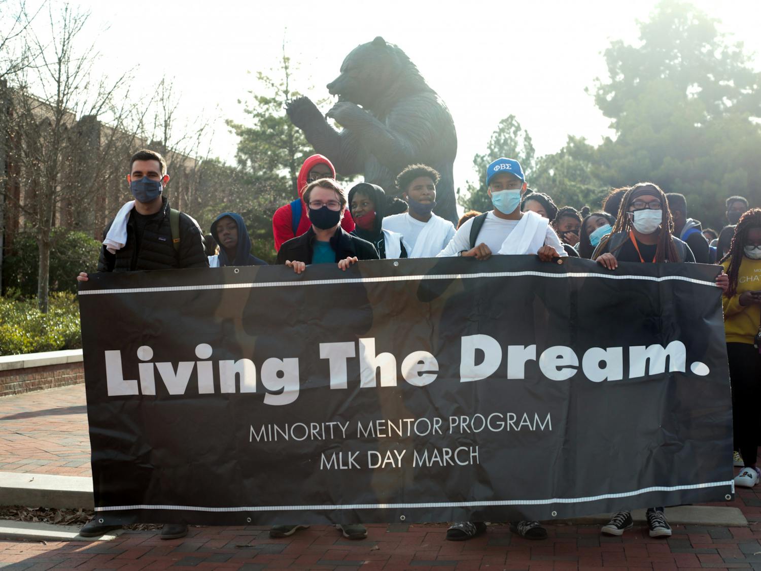 Students prepare to march in honor of Martin Luther King Jr. outside of Mercer’s University Center, holding a banner that says “Living The Dream,&quot; in January 2022. 