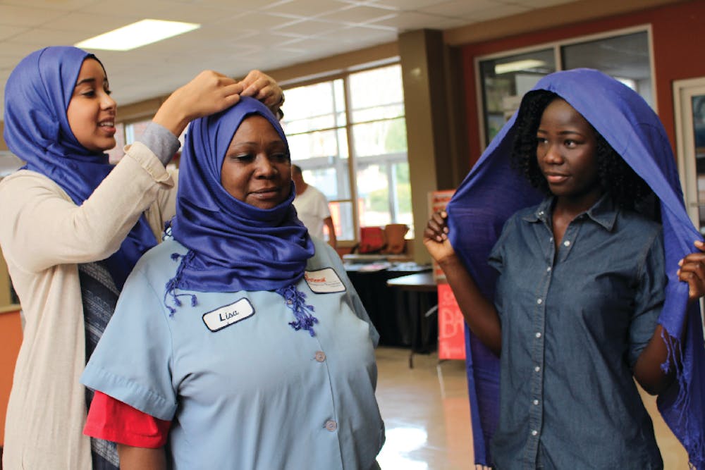 Hiba Yacout, President of the Muslim Student Association, assisted custodian Ms. Lisa put on a Hijab.