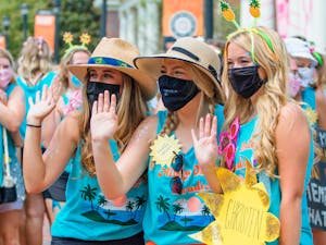 Three members of Alpha Delta Pi wave as they pose for a photo during Bid Day on Sept. 6, 2021. Alpha Delta Pi’s Bid Day theme for this year was "Alpha Delta Paradise."
