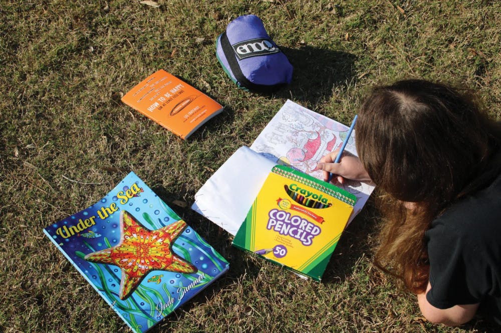 Brianna Levin destresses by coloring in the grass. 