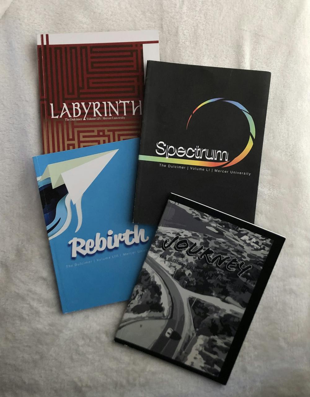 The last four annual issues of The Dulcimer. The most recent publication's theme was "Labyrinth."