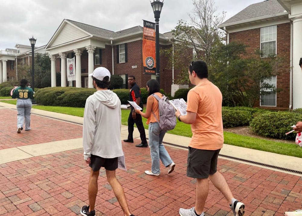 Students and committee members Alex Marshall '27, Ben Cohen '27 and Olivia Woodall '28 walk through Greek Row on the annual Safety Walk on Sept. 29.