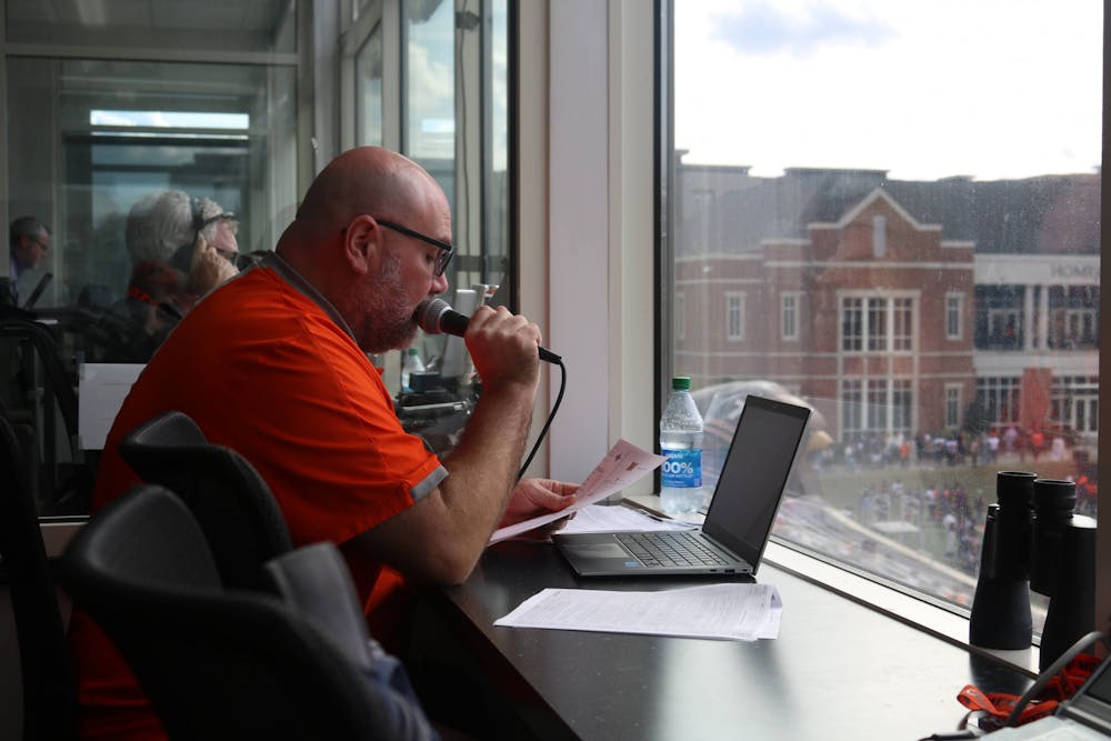 Jimmy McInnis prepares for his role as PA announcer for the Bears, reviewing the roster for Mercer before the football game against Furman on Nov. 12.