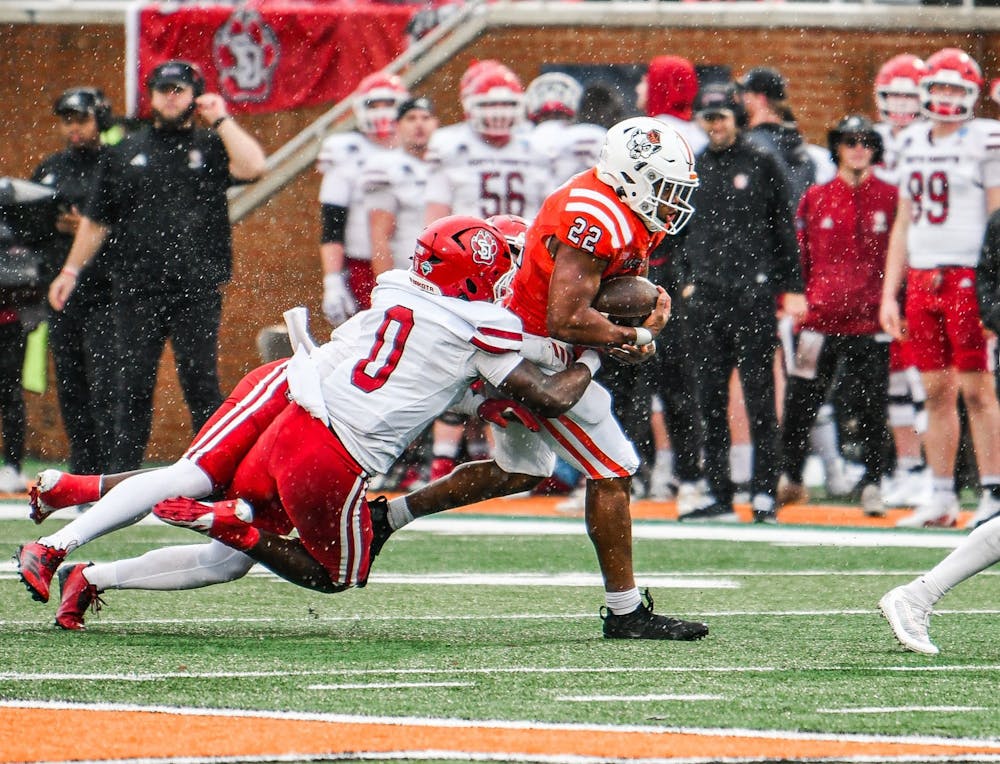 CJ Miller '27 rushes forward, dragging two University of South Dakota players with him. Miller tallied 105 yards on the ground in the 47-0 loss on Dec. 6, 2025.