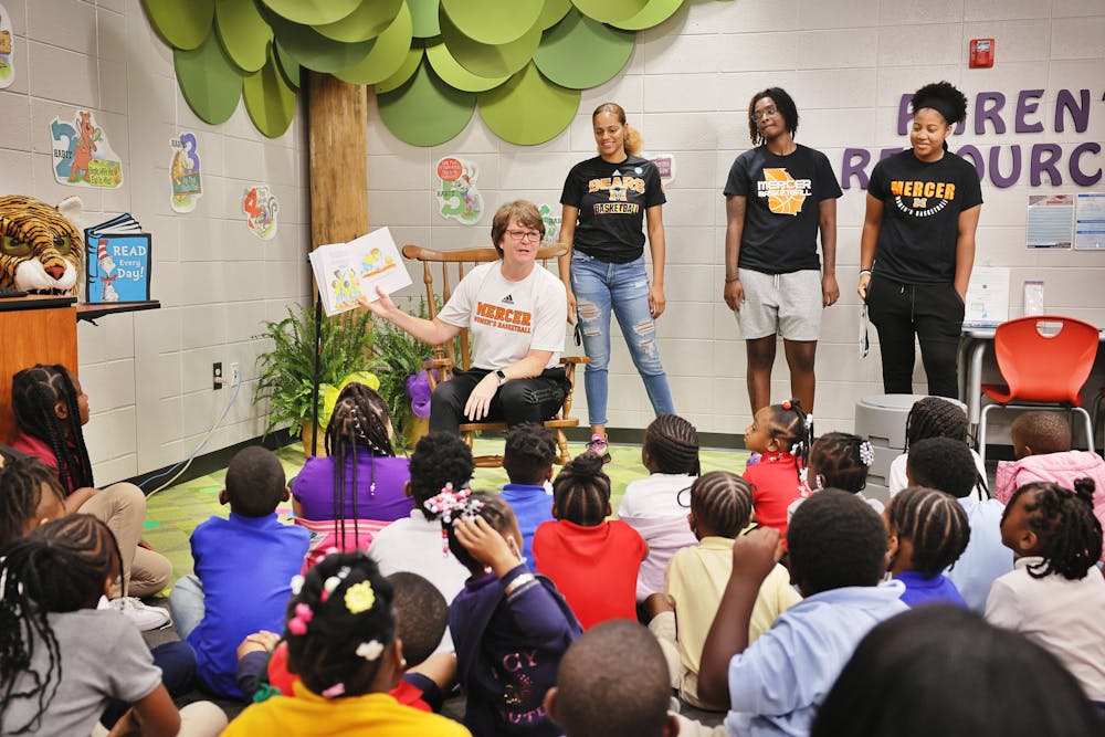 Women’s basketball head coach, Susie Gardner, reads her book, "1, 2,3 Team!" to a group of first graders on Friday, Aug 12. Gardner is in the process of giving her book away to every first grader in the Bibb County public and private schools. (Photo by Leah Yetter)