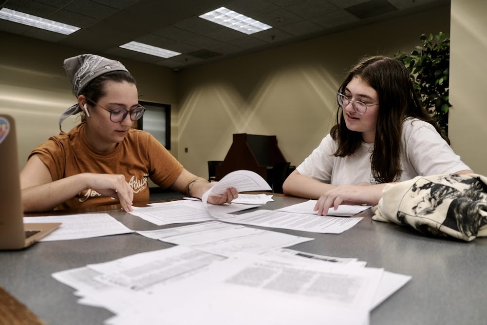 Students Bekehm Mohn and Savannah French meet in the library to read through documents from the archives related to Mercer's queer history for the "We are Here!" research project. 
