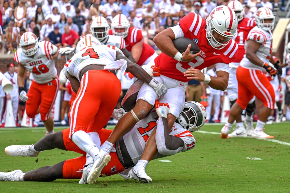 Mercer's Tavion McCarthy ‘24 (#4) and Solomon Zubairu ‘24 (#11) take down Ole Miss' Spencer Sanders (#3) in the game against Ole Miss on Saturday, Sept. 2. The Bears fell to the Rebels, 73-7.