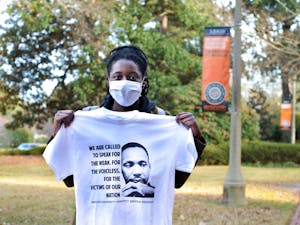 Mercer student Lea Dulcio poses for a photo holding up a t-shirt from the event, in honor of Martin Luther King Jr. and his fight for social justice.