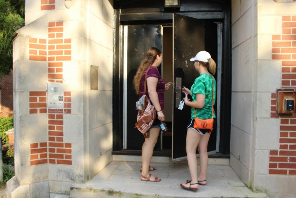 Lauren Buice and Kathryn Heesh walk into Shorter Hall, a building for second year students.
