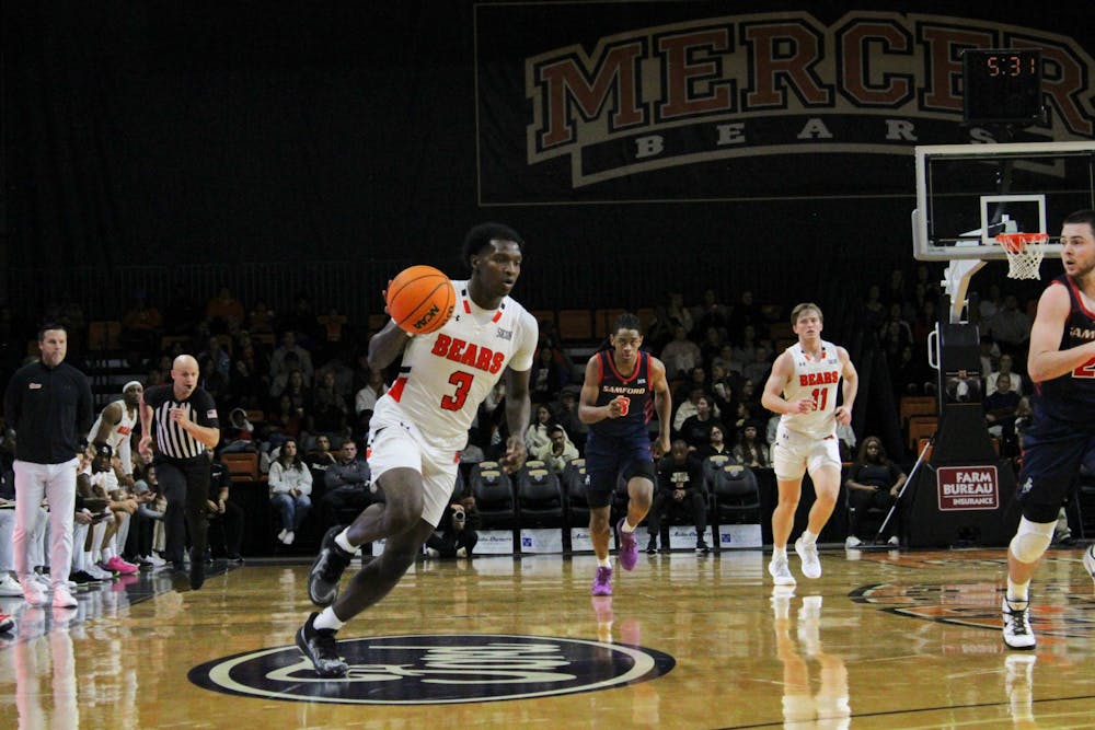 Tyler Johnson '25 drives up the court against Samford University on Wednesday as first-year head coach Ryan Ridder watches on. Johnson dropped 20 points against the Bulldogs, his fifth game this season in which he put up at least 20 points.