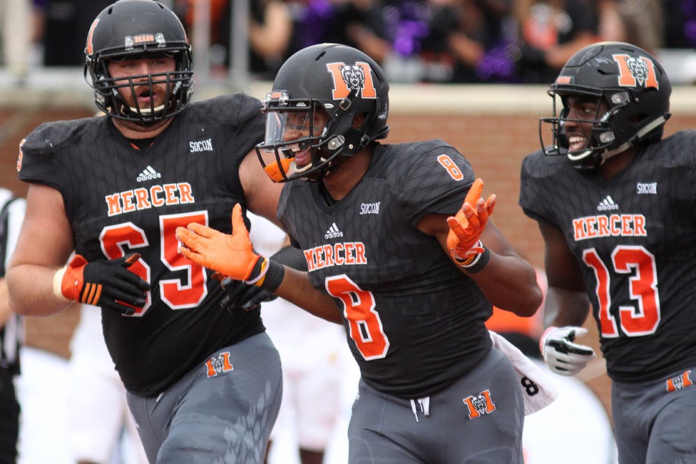 Mercer Bears' Marquise Irvin (8), middle, celebrates with his teammates Caleb Yates (65) and Chandler Curtis (13) after making a touchdown in their game against the Chattanooga Mocs on Saturday, October 14 in Mercer's stadium.
