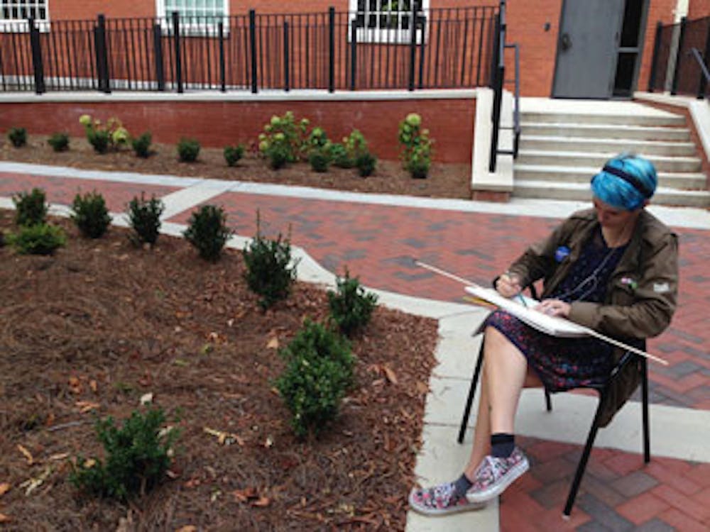 Freshman Art major Isabel Newberry enjoys a morning drawing session outside of Hardman Hall.
