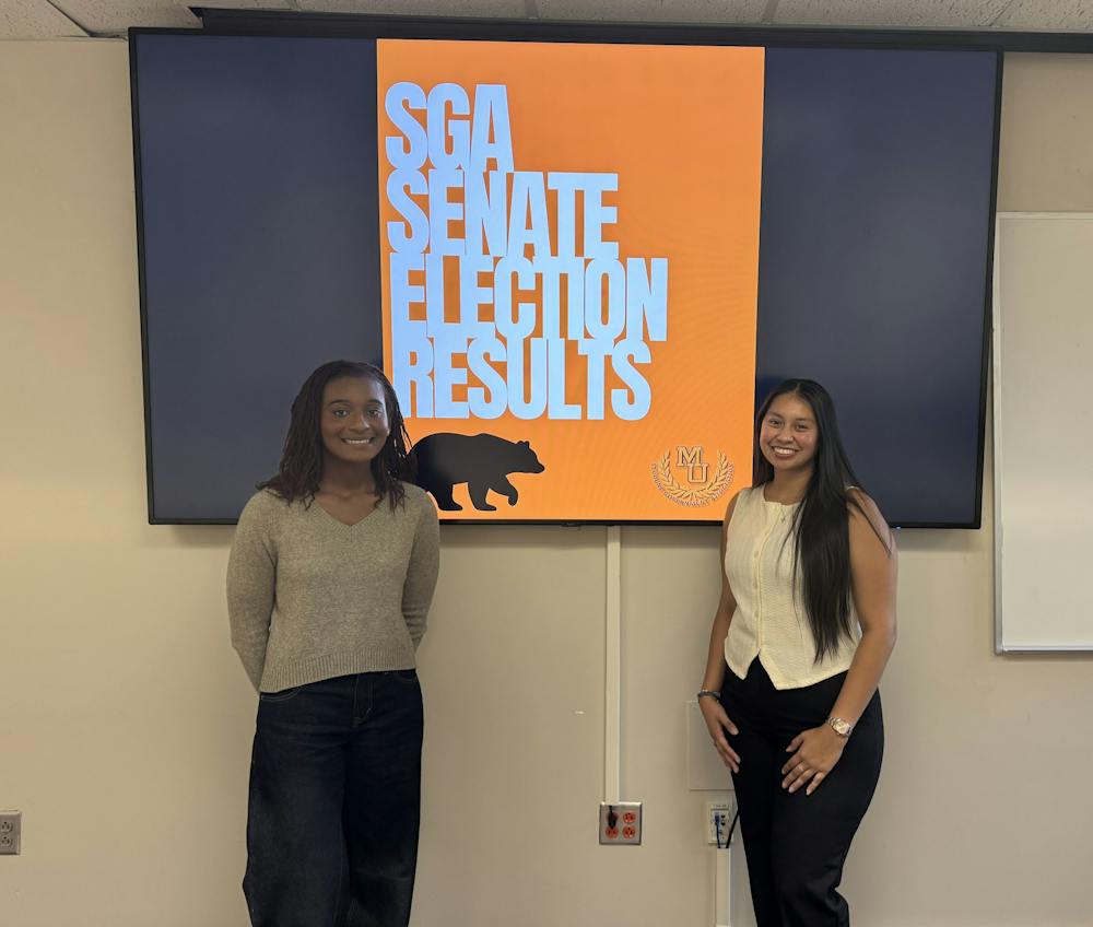 Chloe Jones '28 and Joana Mazariegos ‘27 stand next to the presentation that announced their seats on Sept. 23 in Stetson Hall.