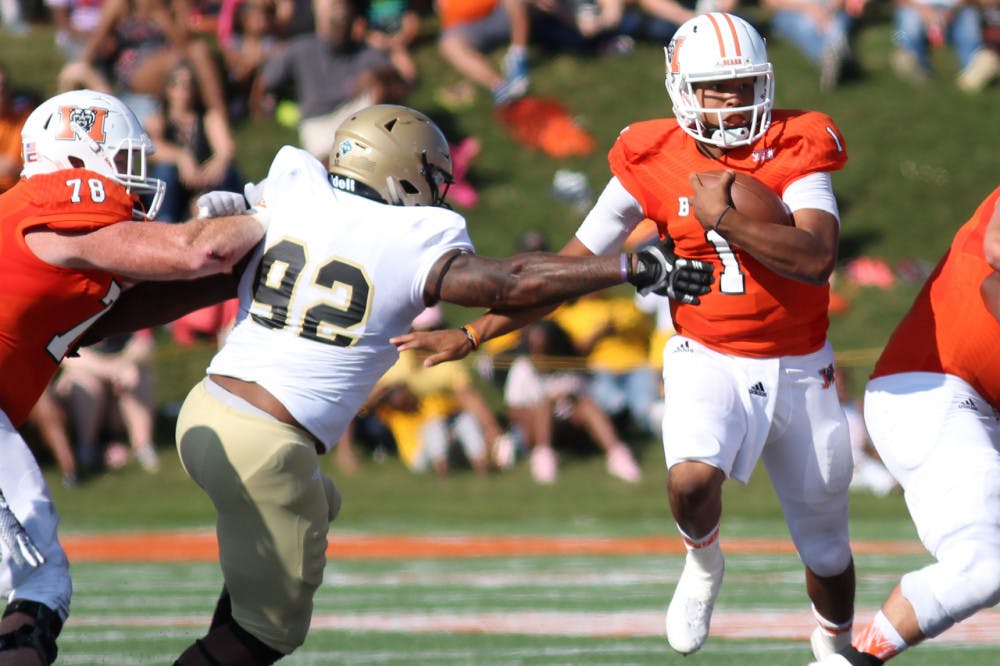 Mercer's quarterback Kaelan Riley (1) runs the ball with Wofford's Tyler Vaughn defening in their game on Saturday, September 9 at Mercer University.