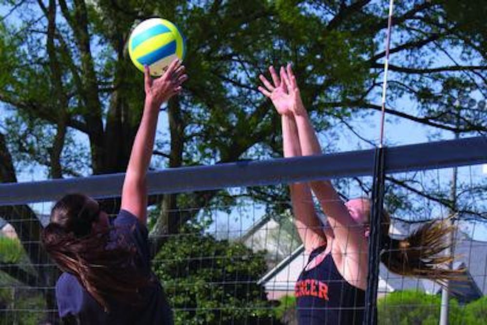 The sand volleyball team runs a drill on setting teammates up for a spike at practice.